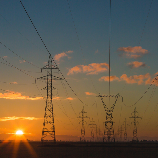 power grid with sun setting in background