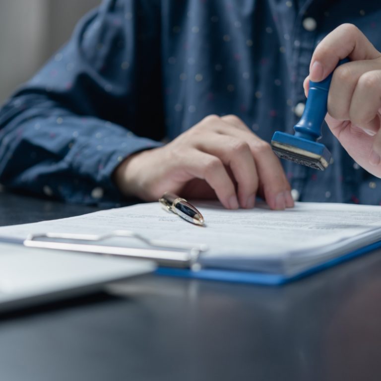 Man signs the documents confirming that the translation was made by qualified linguists