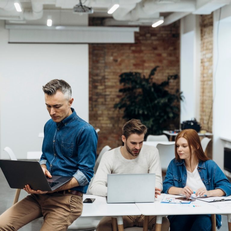 group of ISO-certified Russian translators sits with computers around the table