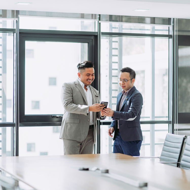 two finance managers looking at phone