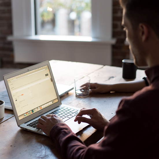 man working at laptop under ISO certified procedures