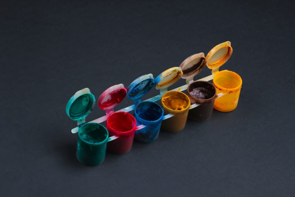 gouache bottles of different colors against blackboard